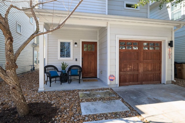 entrance to property with a porch and concrete driveway