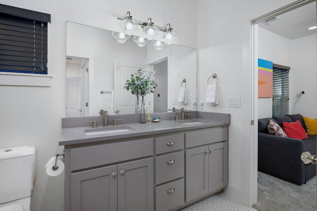 ensuite bathroom with visible vents, a sink, ensuite bath, and double vanity