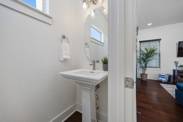 bathroom with baseboards, a wealth of natural light, and wood finished floors