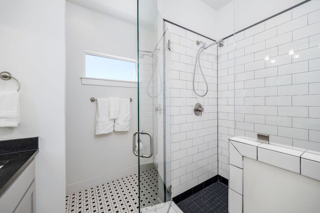 bathroom featuring a stall shower, vanity, and baseboards