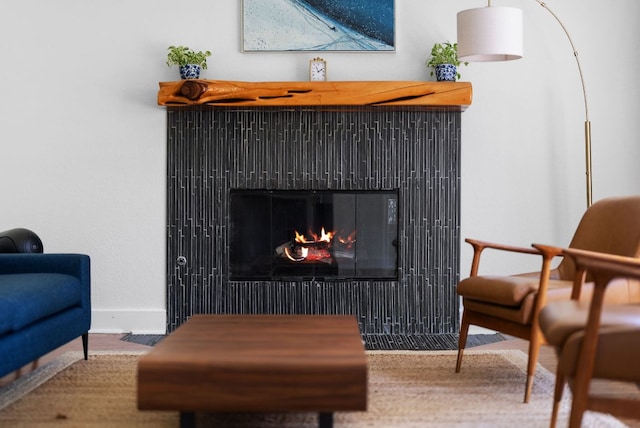 living area with a lit fireplace and baseboards