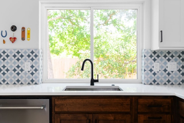 kitchen featuring dark brown cabinetry, a sink, light countertops, stainless steel dishwasher, and decorative backsplash