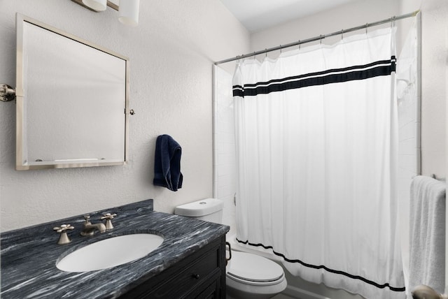 bathroom featuring toilet, a textured wall, shower / bath combo with shower curtain, and vanity