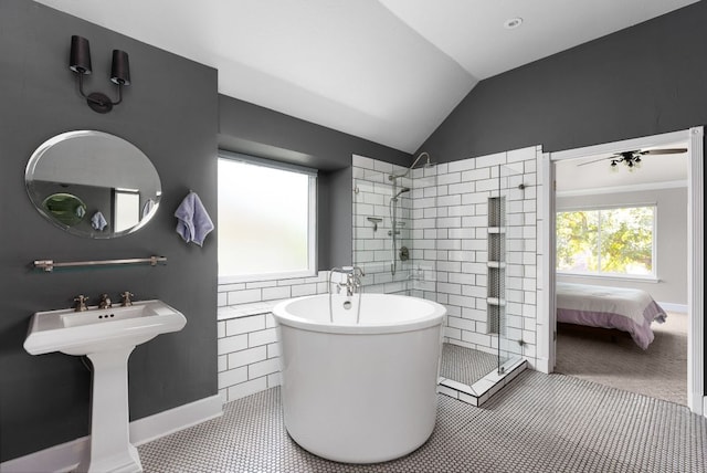 full bath with vaulted ceiling, a tile shower, tile patterned flooring, a freestanding tub, and baseboards