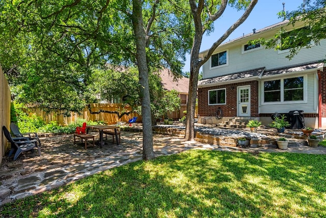 view of yard with entry steps, a patio area, and fence