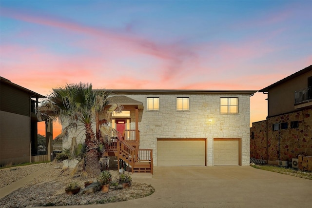 2802 Truman Cv, Lago Vista, TX 78645 - view of front facade with concrete driveway, a garage, stone siding, and stairway