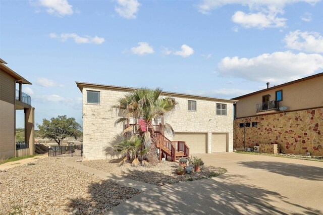 2802 Truman Cv, Lago Vista, TX 78645 - view of front of property with stone siding, an attached garage, stairs, and concrete driveway