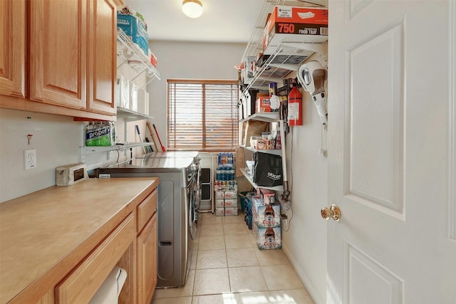 laundry area with light tile patterned floors, independent washer and dryer, and cabinet space