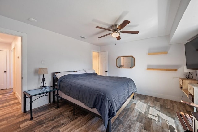 bedroom with a ceiling fan, wood finished floors, visible vents, and baseboards