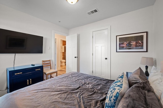 bedroom featuring visible vents and wood finished floors