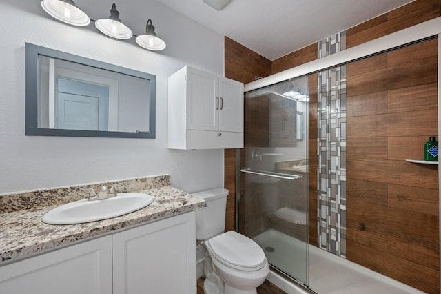 bathroom with a stall shower, vanity, and toilet