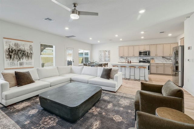 living area with recessed lighting, visible vents, and light wood-style flooring