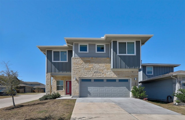 view of front facade featuring a garage, stone siding, driveway, and board and batten siding