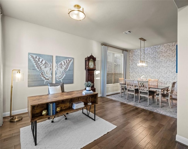 office space featuring wallpapered walls, dark wood-type flooring, visible vents, and baseboards