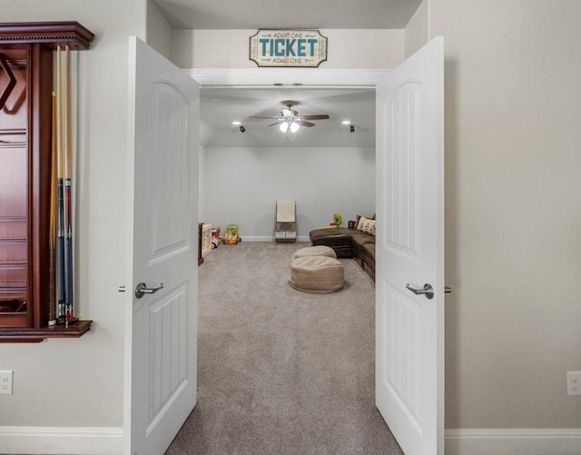 interior space with carpet floors, baseboards, and a ceiling fan