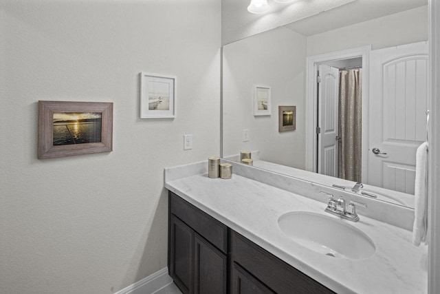 full bathroom featuring vanity and baseboards