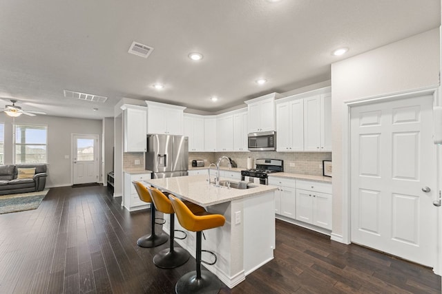 kitchen featuring dark wood finished floors, visible vents, stainless steel appliances, and a sink