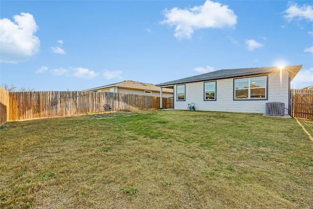 back of house with a fenced backyard, central AC unit, and a yard