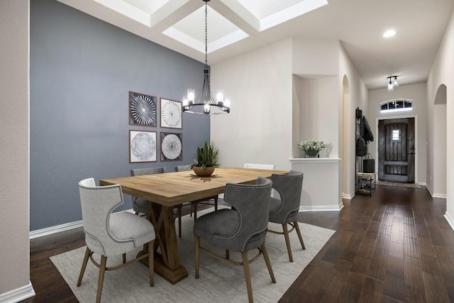 dining area with visible vents, baseboards, arched walkways, hardwood / wood-style floors, and a notable chandelier