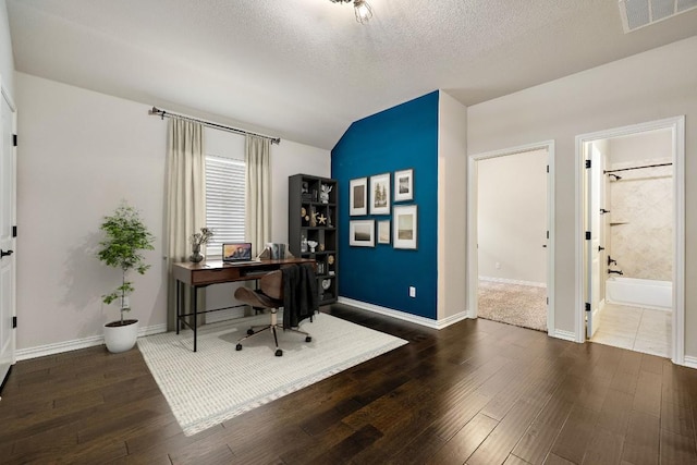 office space featuring lofted ceiling, a textured ceiling, visible vents, and wood finished floors