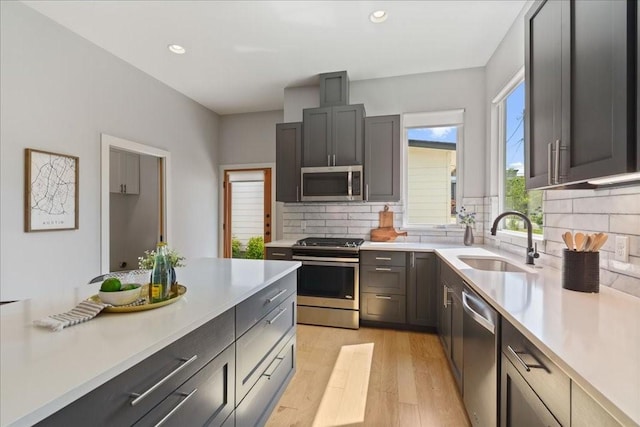 kitchen featuring appliances with stainless steel finishes, light countertops, and a sink