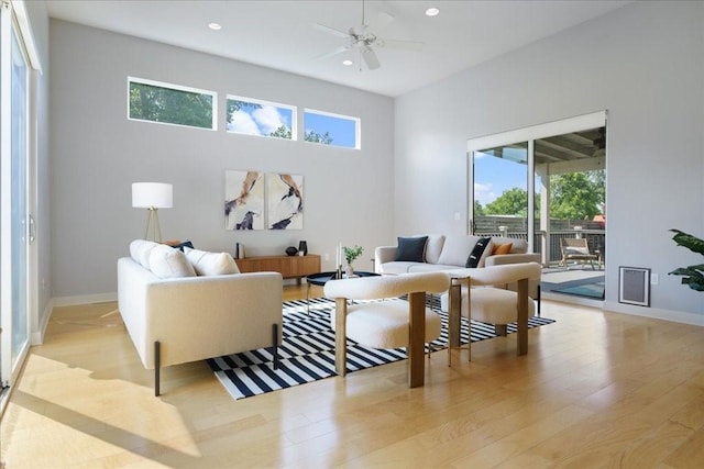 living room with light wood-style flooring, baseboards, a ceiling fan, and recessed lighting