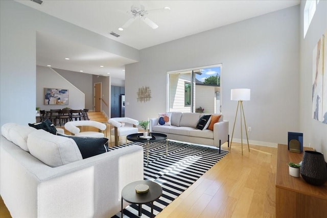 living room featuring light wood finished floors, visible vents, baseboards, a ceiling fan, and recessed lighting