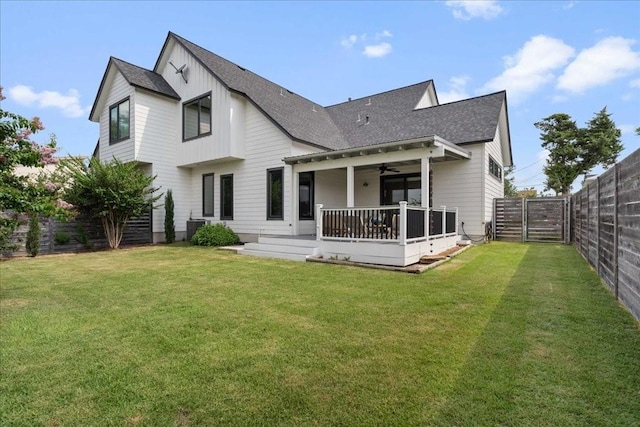 back of house with ceiling fan, central AC unit, a lawn, and a fenced backyard