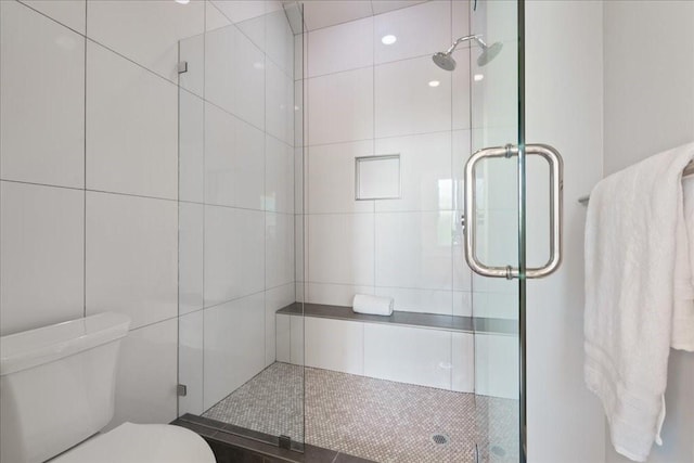 bathroom featuring a shower stall and toilet