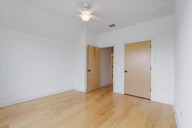 empty room featuring baseboards, a ceiling fan, visible vents, and light wood-style floors