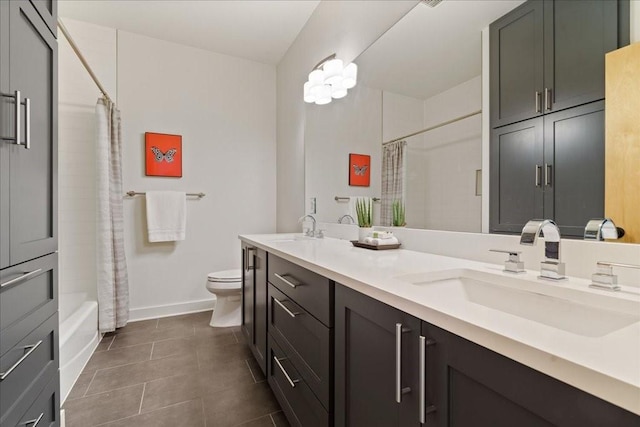 full bath featuring double vanity, a sink, toilet, and tile patterned floors