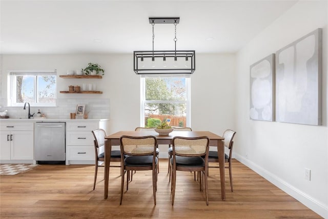 dining area with light wood-type flooring and baseboards