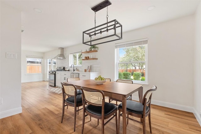 dining area with light wood-style flooring and baseboards