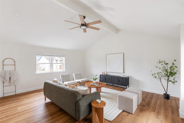 living area featuring light wood-type flooring, lofted ceiling with beams, baseboards, and a ceiling fan