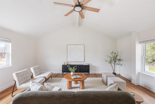 living area with vaulted ceiling with beams, light wood-style flooring, and baseboards