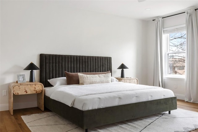 bedroom with baseboards and wood finished floors