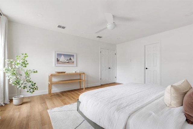 bedroom featuring visible vents, light wood-style flooring, and baseboards