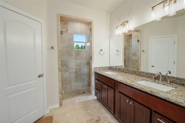 bathroom featuring double vanity, tile patterned flooring, a shower stall, and a sink