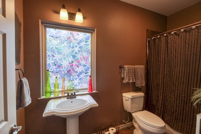 bathroom with curtained shower and toilet