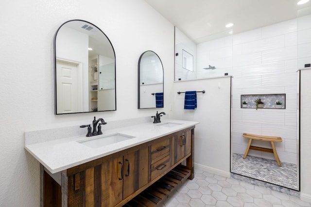 full bathroom with tile patterned flooring, double vanity, a sink, and a walk in shower