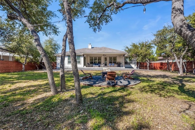 back of house with a yard, an outdoor fire pit, a patio area, and fence