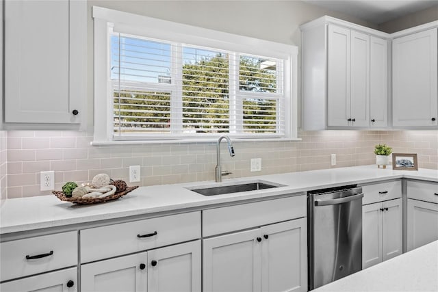 kitchen featuring backsplash, white cabinetry, light countertops, and a sink