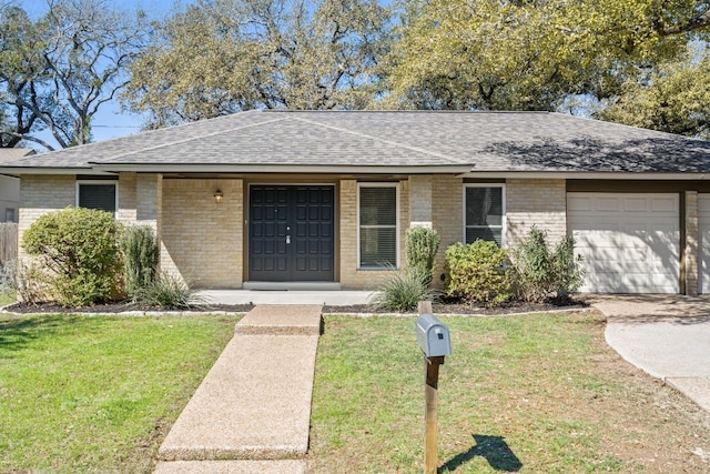 ranch-style home with a garage, driveway, roof with shingles, a front yard, and brick siding