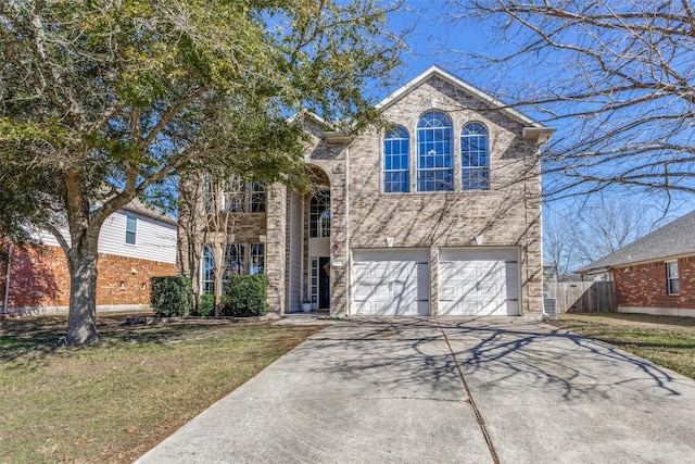 traditional-style home featuring an attached garage, brick siding, fence, concrete driveway, and a front yard