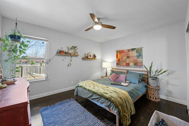 bedroom with ceiling fan, baseboards, and wood finished floors