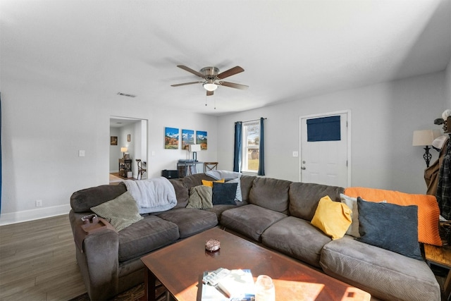 living area with visible vents, dark wood finished floors, baseboards, and ceiling fan