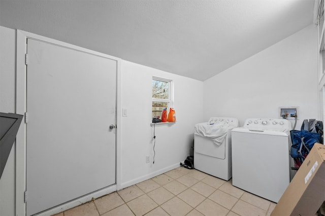 washroom with light tile patterned floors, laundry area, separate washer and dryer, and a textured ceiling