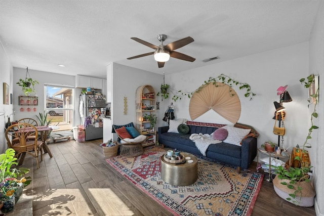 living room featuring ceiling fan, visible vents, and wood finished floors