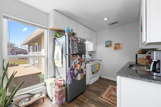 kitchen featuring a sink, visible vents, white cabinetry, freestanding refrigerator, and white range with electric cooktop