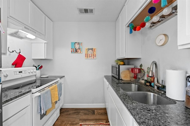 kitchen featuring visible vents, stainless steel microwave, electric range, white cabinets, and a sink